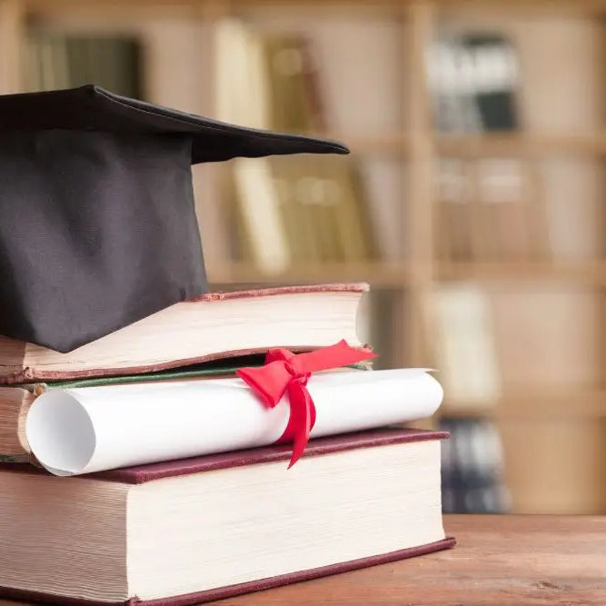 Capello di laurea e diploma su libri per riscatto laurea agevolato nel 2025.